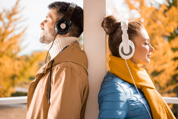 Young man and woman standing in headphones — Stock Photo, Image