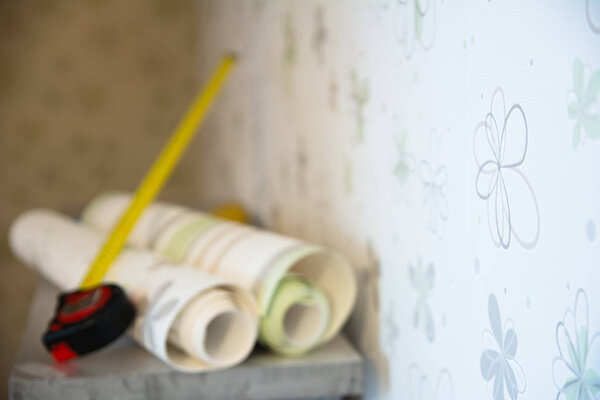 Two rolls of wallpaper and a measuring tape — Stock Photo, Image