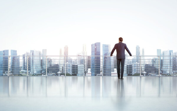 Businessman standing on a roof and looking at city — Stock Photo, Image