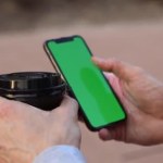 Close up, hands of Caucasian man holding cup of coffee and smartphone with green screen, chroma key, scrolling, touching screen. Side view. Mock up. Technology concept, online shopping, communication.