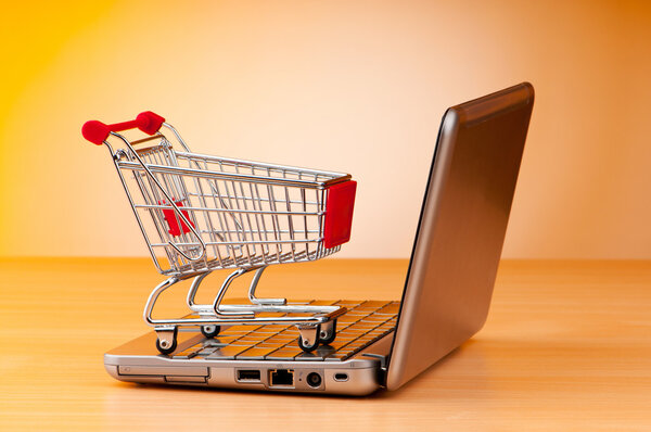 Internet online shopping concept with computer and cart — Stock Photo, Image